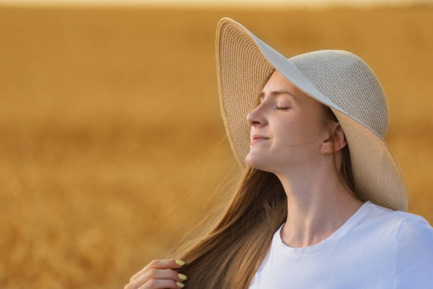 Portrét krásné mladé ženy v klobouku na teplém neutrálním pozadí - Fotografie, Obrázek