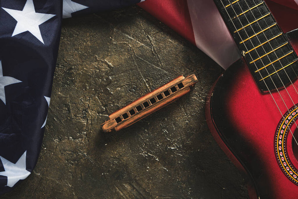 Hvězdicová vlajka, kytara a harmonika na tmavém pozadí. Hudební nástroj a vlajka Spojených států amerických - Fotografie, Obrázek