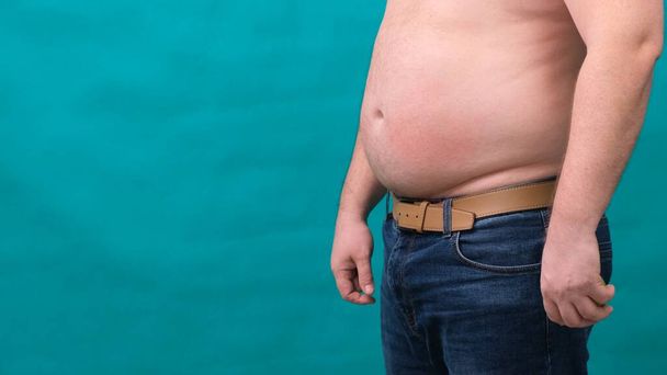 macho com uma barriga grande mostra sua gordura em uma tela verde. O conceito de alimentação saudável e perder peso, dieta
 - Foto, Imagem