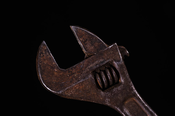 old rusty adjustable spanner on a black background - Fotó, kép