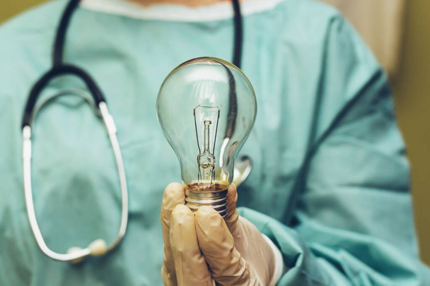 Крупный план хирурга держать лампочку, творческая идея, вдохновение, новая идея и инновации концепции
 - Фото, изображение