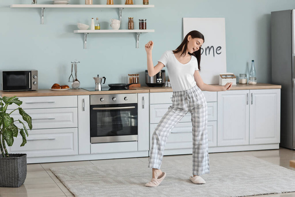 Beautiful young woman dancing in kitchen - Foto, afbeelding