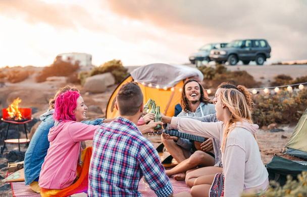 Happy friends toasting beers at barbecue camping party - Groupe jeunes hipster people having fun dining and drinking together in camping - Travel vacation lifestyle and youth culture concept
 - Photo, image