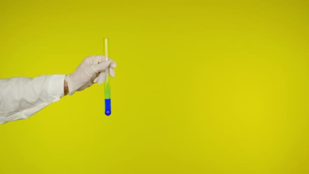 Handschuhschutz aus Latex zeigt ein Glasrohr mit der blauen Substanz - Filmmaterial, Video