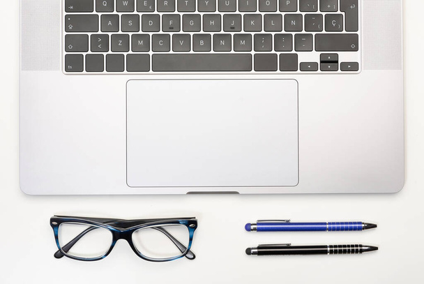 Top view of workspace, laptop, glasses and pens. Business concept.  - Fotó, kép
