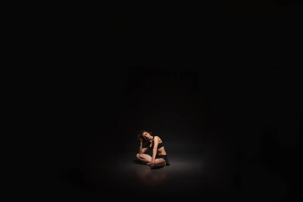 Young girl doing yoga on a black background - Foto, Bild