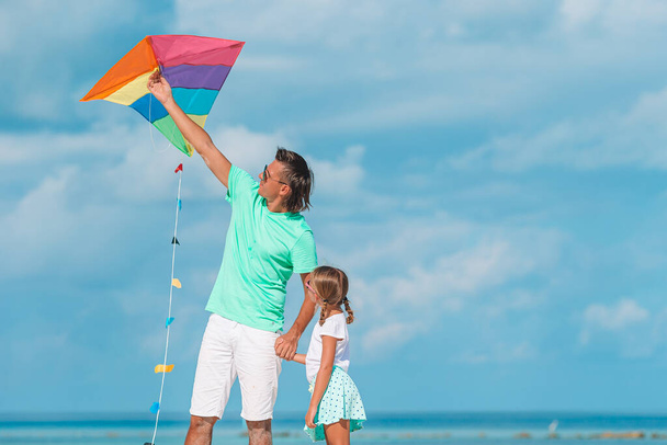 Family flying kite together at tropical white beach - Photo, Image