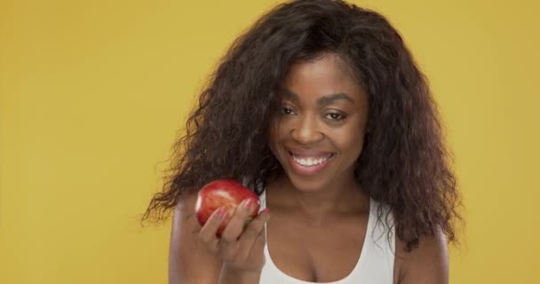 Black woman eating fresh apple - Felvétel, videó