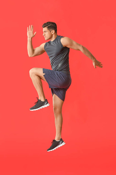 Sporty jumping man on color background - 写真・画像