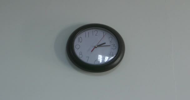Horloge ronde murale noire et blanche avec numéro et dans le sens des aiguilles d'une montre tout droit sortie ou terminer le travail et après l'école sur un mur blanc vintage ou une table de vue du dessus avec espace 4K
 - Séquence, vidéo