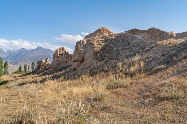 A vista da antiga cidade arruinada Koshoy Korgon e da muralha da cidade de argila no Quirguistão
 - Foto, Imagem