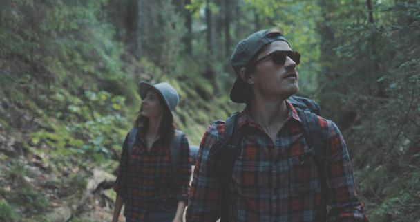 young man and woman hiking in forest - Фото, зображення