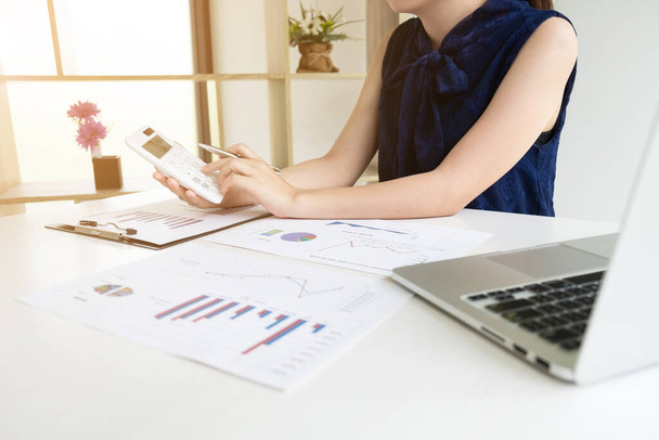 Бизнес-женщины подсчитывают доходы от графиков в комнате и работы из дома, Финансы и бухгалтерская концепция
. - Фото, изображение