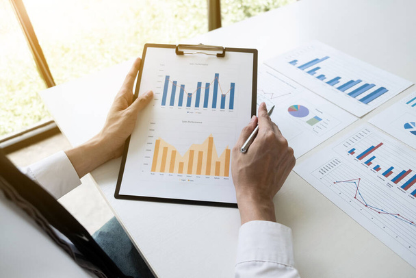 Podnikatel analyzuje marketingovou strategii z grafu prodejní výkonnosti v kancelářské místnosti, Finance a účetní koncepci. - Fotografie, Obrázek