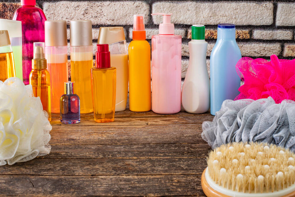Monenlaisia shampoo ja suihku geeli pullot ja sieni pöydällä
 - Valokuva, kuva