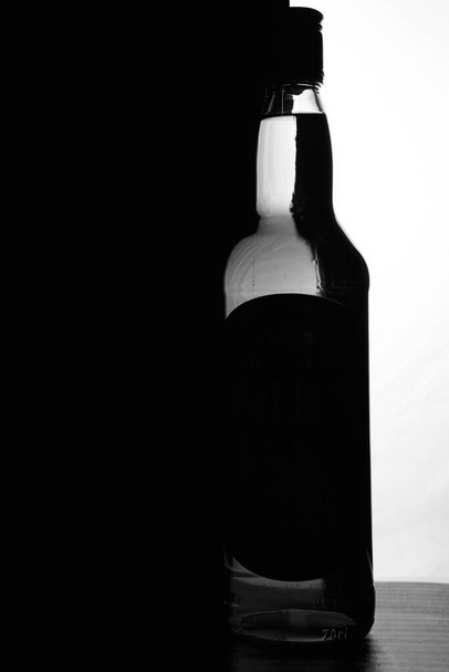 黒と白の背景にウイスキーのボトル。光学効果。高品質の写真 - 写真・画像