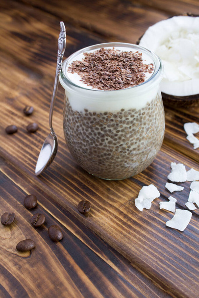 Coffee pudding with chia, coconut milk and chocolate  in the glass jar on the brown wooden background.  Location vertical. - Photo, Image