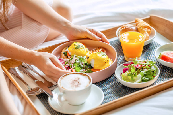 Breakfast in Bed with Coffee, Orange Juice, Salad, Fruits and Eggs Benedict - Foto, Bild