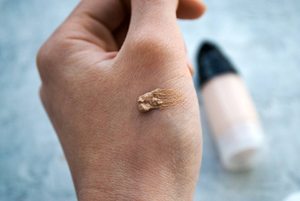Foundation on the hand. Woman picks a shade of foundation. - Photo, Image