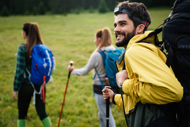 Group of friends trekking with backpacks walking outdoor - Foto, Imagen