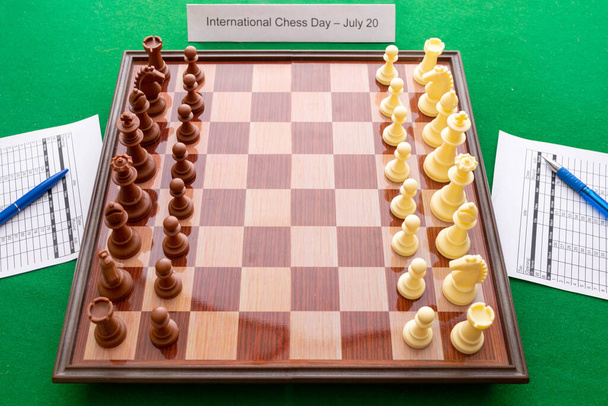 Yeşil arkaplanda satranç resmi. Dünya Satranç Günü. Uluslararası Satranç Günü. 20 Temmuz. Yan görünüm. - Fotoğraf, Görsel