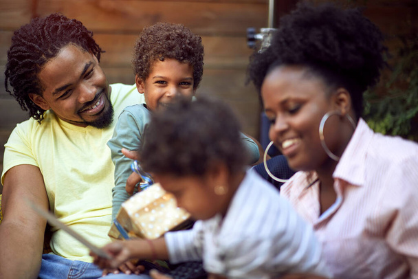 Happy Afro-American young family enjoying together outdoor at birthday party. - Fotoğraf, Görsel