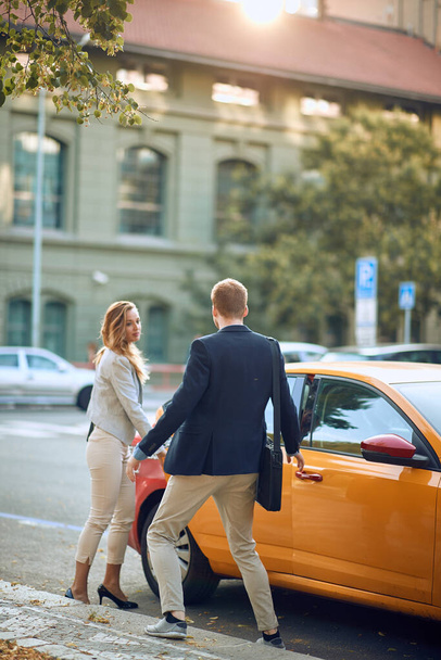 young business couple entering a cab in the street - Fotografie, Obrázek
