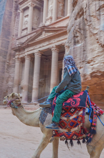 Un bedouin local sur une promenade à dos de chameau devant le célèbre Trésor public, un chef-d'œuvre sculpté dans la montagne, Petra, Jordanie
.  - Photo, image
