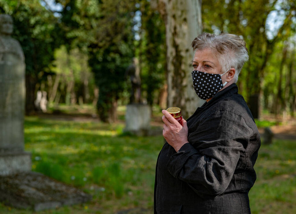 Starší žena v masce na hřbitově - Fotografie, Obrázek