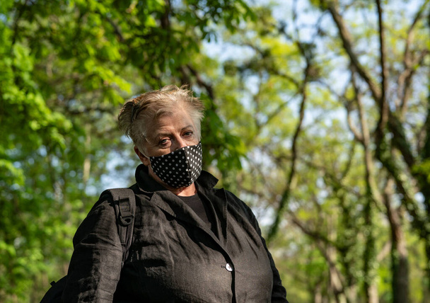 Senior woman in mask in a cemetery - Photo, Image