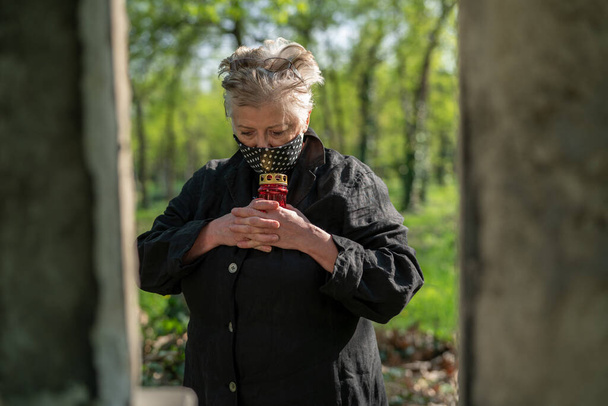 Seniorin mit Maske auf Friedhof - Foto, Bild