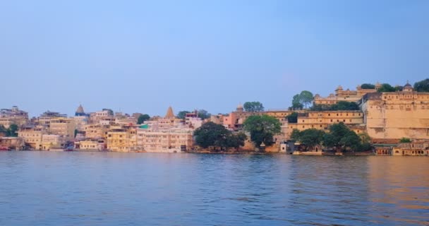 Udaipur City ghat Lal ghat en Udaipur City Palace panoramisch uitzicht vanaf het meer Pichola. Rajput architectuur van Mewar dynastie heersers van Rajasthan. Udaipur, India - Video