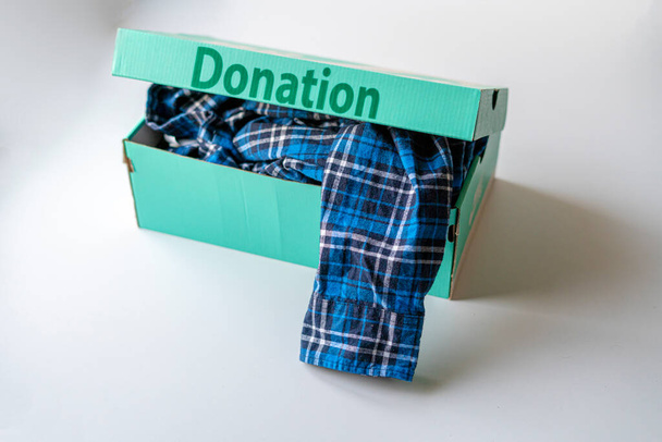 kartónová krabice s oblečením uvnitř, dar pro děti z chudých zemí - Fotografie, Obrázek