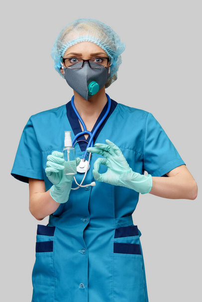 medical doctor nurse wearing protective mask - holding bottle of sanitizing spray or gel - Photo, Image
