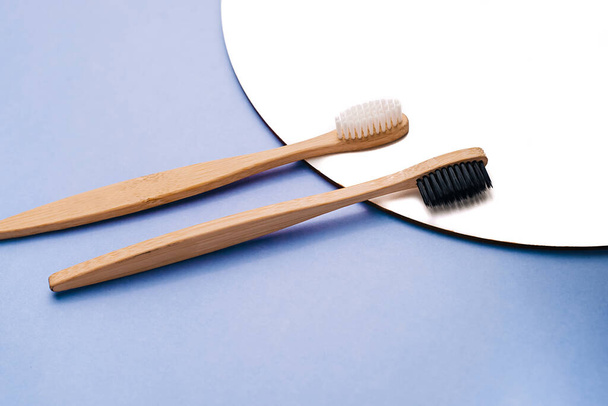 Dental care and zero waste concept. Flat lay composition with eco natural bamboo toothbrushes on pastel blue background. Top view, copy space. Layout natural organic hygiene products - Foto, afbeelding