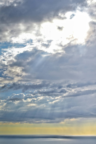 タスマン海の地平線の上に雨の雲を通して太陽が輝く - 写真・画像
