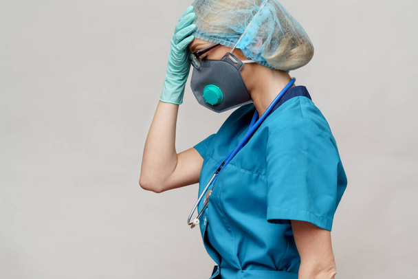 female doctor with stethoscope wearing protective mask and latex gloves over light grey background - Foto, imagen