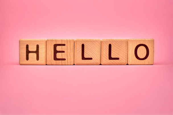 Hello word made with building blocks, business concept. Text Hello on pink background. Global mass gathering allowed. Greeting background, Hospitality, hello sign for visitors, guests, clients - Photo, Image