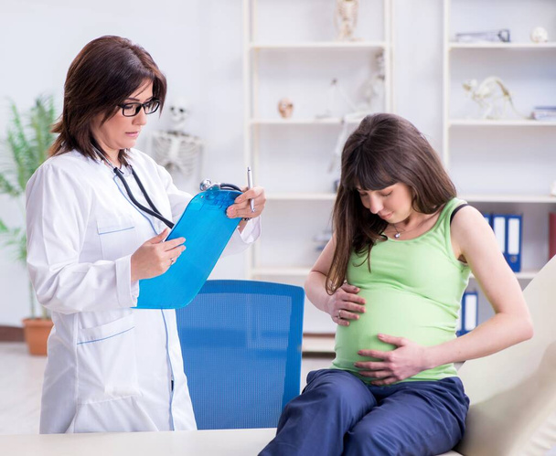 Беременная женщина посещает врача для регулярного осмотра - Фото, изображение