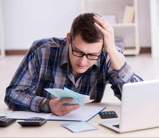 Mladý muž frustrovaný z jeho domu a daňových účtů - Fotografie, Obrázek