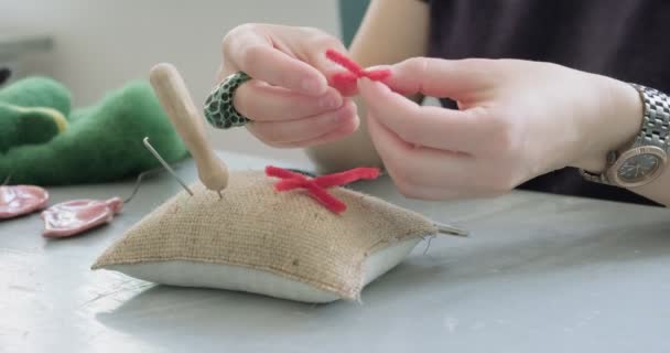 Egy nő gyapjú játékszert készít az asztalnál, közelről. Nő ül, és létre tölgyfa baba otthon. Tű Felted Kézzel készített és kreatív készségek - Felvétel, videó