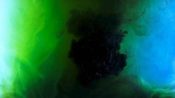 Värikäs savuinen virtaus sekoitettu värejä vedessä. Varastomateriaalia. Monivärisen musteen levittäminen paljeteilla vedessä. Maalivirtojen makrovalokuvaus - Valokuva, kuva