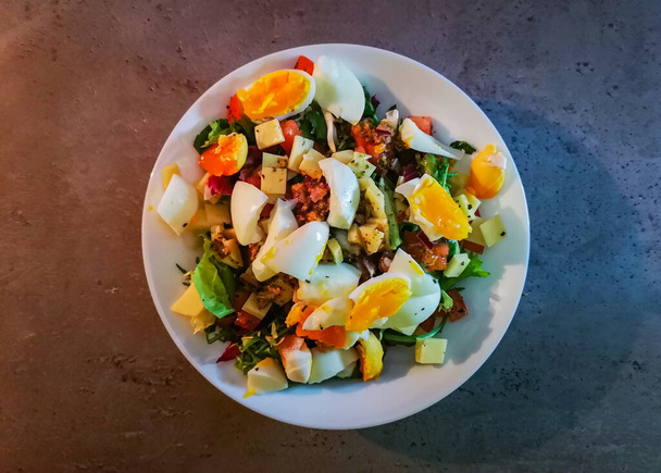 Salad with boiled eggs, mix of salads, vinaigrette and cheese - Foto, afbeelding