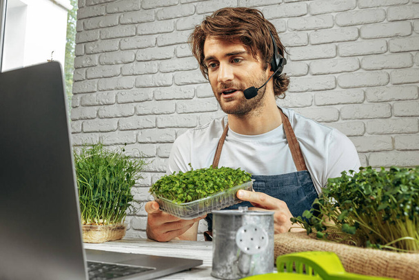 Young caucasian man selling micro green sprouts online - Foto, Bild