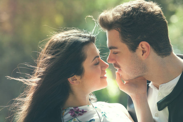 Junges Paar, das sich im Freien in einem Park liebt. Ein junger Mann und eine junge Frau umarmen sich mit Leidenschaft und Gefühl. Liebe und Verliebtheit. Schwarz-Weiß - Foto, Bild