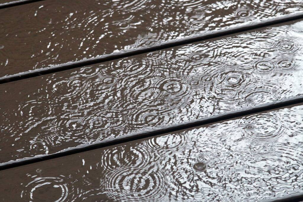 Gotas de lluvia en el suelo de una terraza en un día lluvioso
. - Foto, imagen
