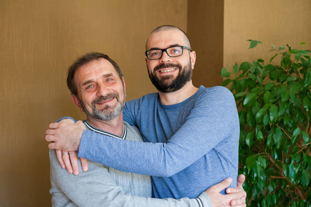 Portrait of happy smiling father and his adult son. Man hugging his elderly father. Father's day concept. - Foto, immagini