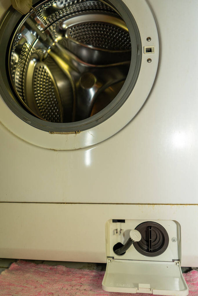 reiniging van het wasmachinefilter. het filter in de wasmachine is vuil - Foto, afbeelding