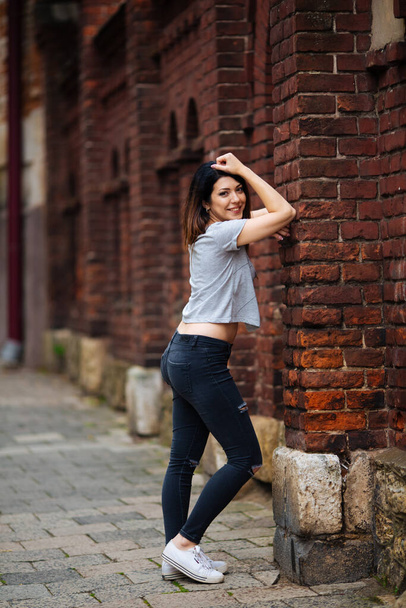 beautiful girl near the wall in jeans - Photo, Image