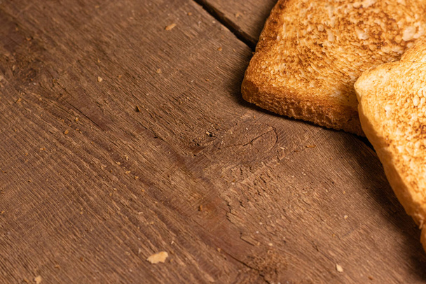 Tasty fried toast bread slices lie on a natural brown wooden background. Simple rustic style. - Foto, Bild
